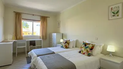 a bedroom with a bed and a desk and a window at Wave by Check-in Portugal in Albufeira