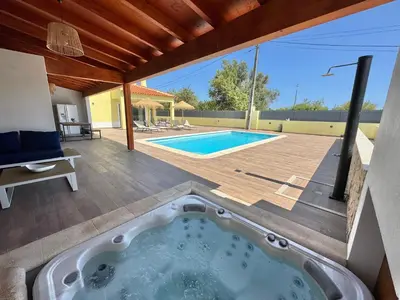 a hot tub on a deck next to a swimming pool at Villa 20age - Jacuzzi - Heated pool - Algarve in Albufeira