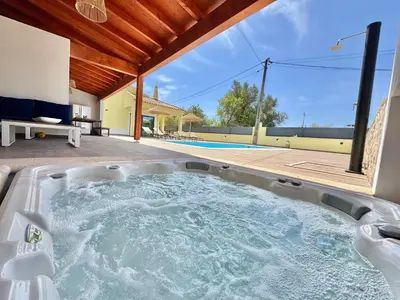 a jacuzzi tub in the backyard of a house at Villa 20age - Jacuzzi - Heated pool - Algarve in Albufeira