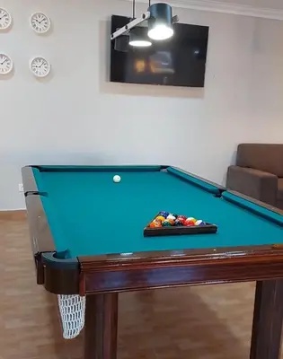a pool table in a living room with at Casinha da Galé in Galé