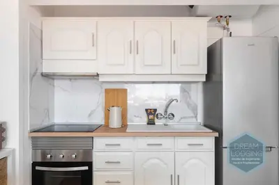 a kitchen with white cabinets and a sink and a refrigerator at Alamos - Dream Lodging in Albufeira