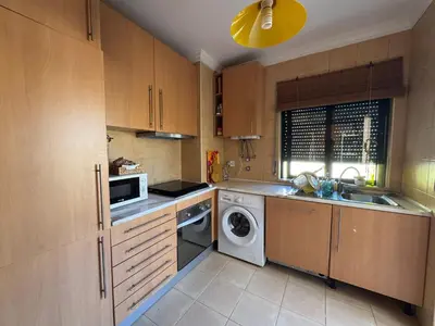 a kitchen with a washing machine and a sink at T1 dos Salgados in Guia