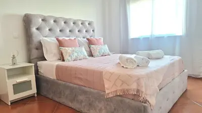 a large bed with two towels on top of it at albufeira sweety house in Albufeira