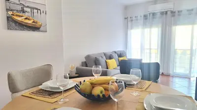 a dining room table with a bowl of fruit and wine glasses at albufeira sweety house in Albufeira