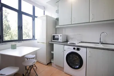a kitchen with a washing machine and a microwave at Modern 3-bedroom Retreat in Faro's City Center in Faro