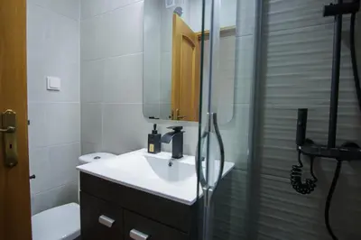 a bathroom with a sink and a shower with a mirror at Modern 3-bedroom Retreat in Faro's City Center in Faro