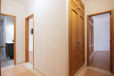 a hallway with a wooden door and a mirror at Modern 3-bedroom Retreat in Faro's City Center in Faro