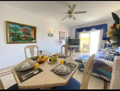 a living room with a table and a dining room at Vilamoura Central in Quarteira