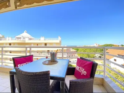 a table and chairs on a balcony with a view of the ocean at Vilamoura Central in Quarteira