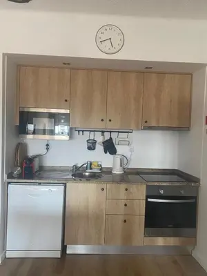 a kitchen with a table with plates and a refrigerator at LizHolidays in Albufeira