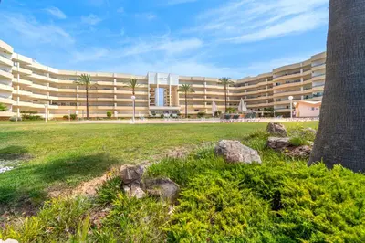 a large building with palm trees in front of a field at Apartment Galé Mar By Zimzala & Bedzy in Guia