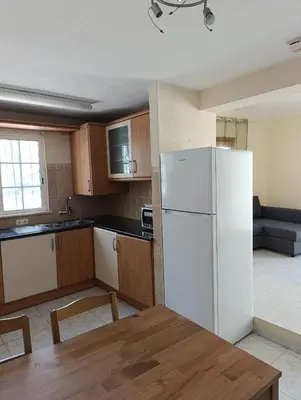 a kitchen with a white refrigerator and a table at Casa Gomez C in Albufeira