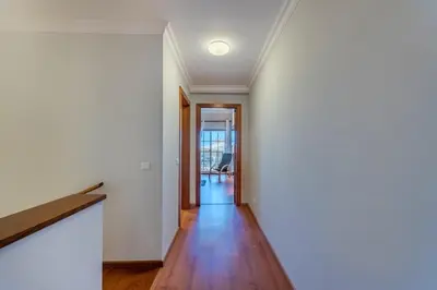 an empty hallway with white walls and wooden floors at Sao Rafael TownHouse with Pool in Albufeira