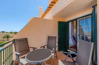 a patio with a table and chairs on a balcony at Sao Rafael TownHouse with Pool in Albufeira