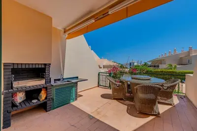 an outdoor patio with a table and a fireplace at Sao Rafael TownHouse with Pool in Albufeira