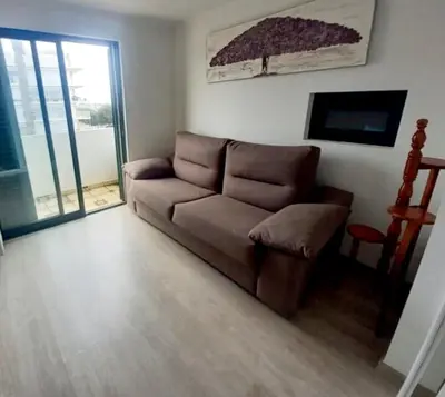 a living room with a brown couch and a television at Villa David in Albufeira