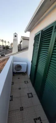 a balcony with green doors and a tile floor at Villa David in Albufeira