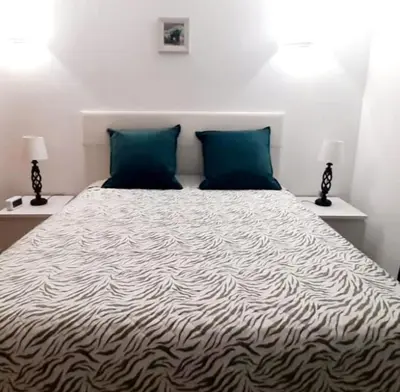 a bedroom with a large bed with two blue pillows at Villa David in Albufeira