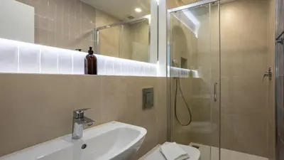 a white kitchen with a sink and a window at Carmo Suites in Faro