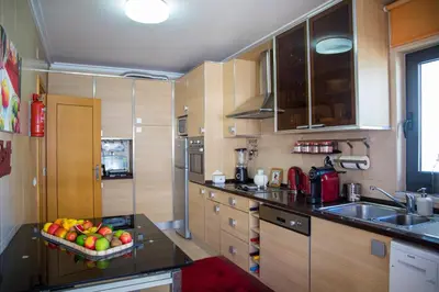 a kitchen with a bowl of fruit on a counter at Apartamento Dubai By Garvetur in Quarteira