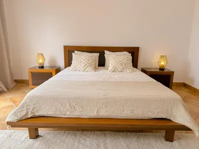 a bedroom with a large bed with two night stands at Casa Vaga - Garrão beach House