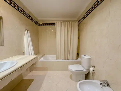 a bathroom with a toilet and a sink and a tub at Casa Vaga - Garrão beach House