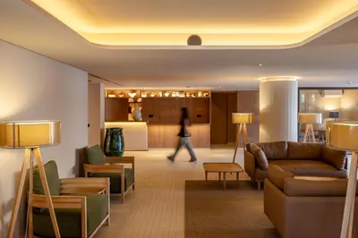 a woman walking through a lobby of a hotel at 3HB Falesia Beach in Albufeira