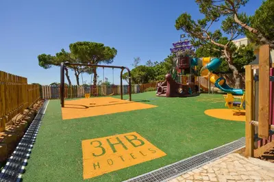 a playground with a slide and a swing at 3HB Falesia Beach in Albufeira