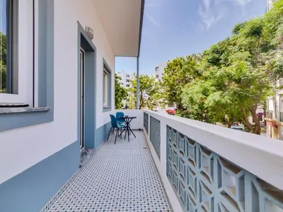 a balcony with a table and chairs on it at Casa da Avó Marquinhas in Quarteira