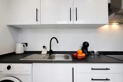 a white kitchen with a sink and a dishwasher at Mi Casa Es Su Casa Nº1 in Albufeira