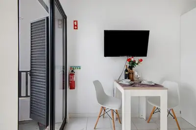 a white room with a table and a tv at Mi Casa Es Su Casa Nº3 in Albufeira