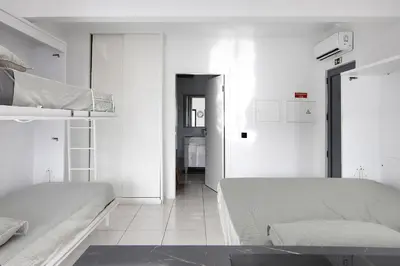 a white bedroom with two beds and a hallway at Mi Casa Es Su Casa Nº3 in Albufeira
