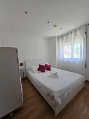 a white bedroom with a bed with red pillows at APT T2 - Marina de Albufeira in Albufeira