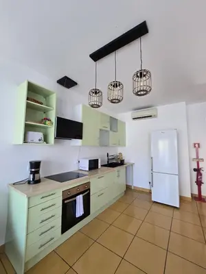 a kitchen with green cabinets and a white refrigerator at APT T2 - Marina de Albufeira in Albufeira