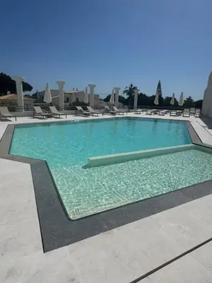 a large swimming pool with chairs in a resort at HC2 Village Vilamoura in Quarteira