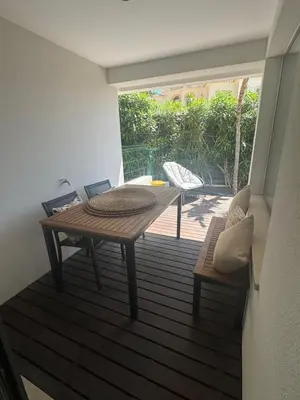 a wooden table and bench on a deck with a patio at HC2 Village Vilamoura in Quarteira