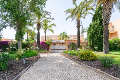 a driveway with palm trees and a building at Coastal Pines by Seareen in Quarteira