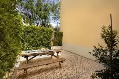 a balcony with a table and chairs and windows at Casinha Amorosa in Faro