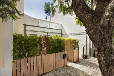 a wooden fence in front of a white building at Casinha Amorosa in Faro