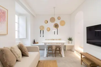 a white living room with a couch and a table at Casinha Amorosa in Faro