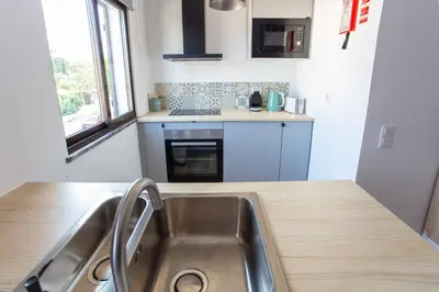 a kitchen with a sink and a counter top at Go4Portugal - Solaina - Modern Condo with AC and Private Balcony in Albufeira