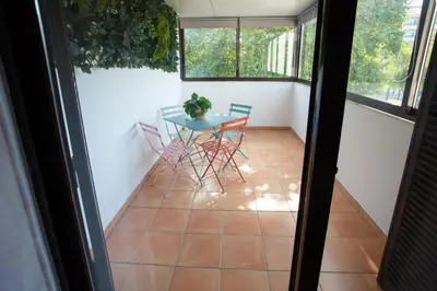 a balcony with a table and chairs on a tiled floor at Go4Portugal - Solaina - Modern Condo with AC and Private Balcony in Albufeira