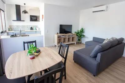 a living room with a table and a couch at Go4Portugal - Solaina - Modern Condo with AC and Private Balcony in Albufeira