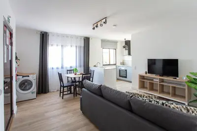 a living room with a couch and a dining room at Go4Portugal - Solaina - Modern Condo with AC and Private Balcony in Albufeira