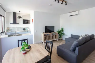 a kitchen and a living room with a table and a couch at Go4Portugal - Solaina - Modern Condo with AC and Private Balcony in Albufeira