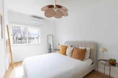 a white bedroom with a bed and a window at Golden Nest - Faro Old Town in Faro