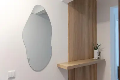 a mirror on a wall next to a wooden shelf at Golden Nest - Faro Old Town in Faro