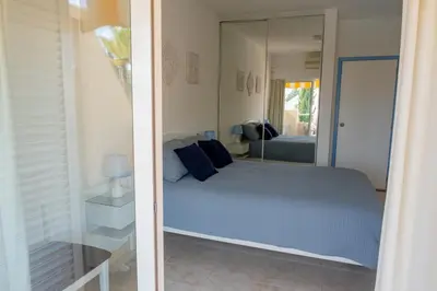 a bedroom with a blue bed and a mirror at Apartamento T2 duplex - Vilamoura in Quarteira