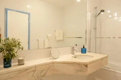 a white bathroom with a sink and a mirror at Apartamento T2 duplex - Vilamoura in Quarteira