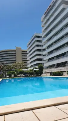 a large swimming pool in front of two buildings at The Navigator Olympus in Quarteira